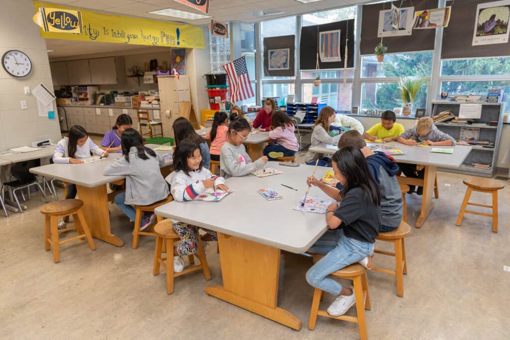 Execute an Art Fundraiser for Schools with Art to Remember image shows room full of kids